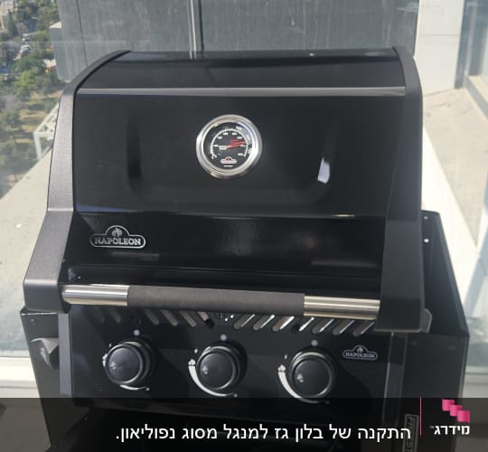 גריל גז שחור על מרפסת עם נוף עירוני